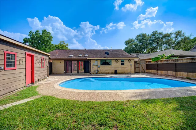 a front view of a house with swimming pool having outdoor seating