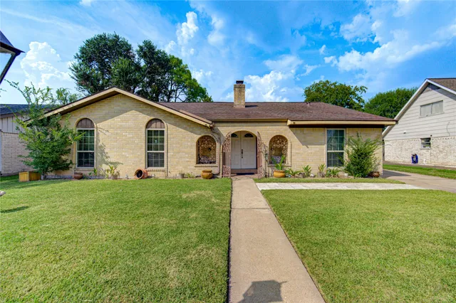 a front view of a house with yard and green space
