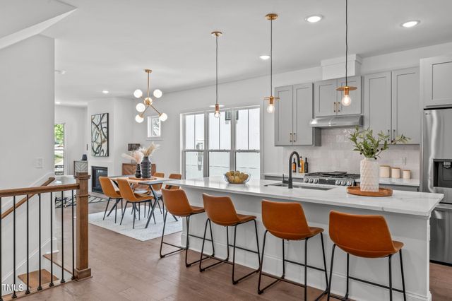 a kitchen with stainless steel appliances kitchen island granite countertop a table and chairs in it