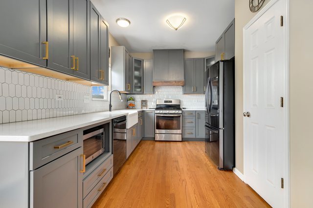 Undisclosed Address Bartlett, IL 60103 - Photo 12 of 45 a kitchen with granite countertop stainless steel appliances cabinets a sink and a wooden floor