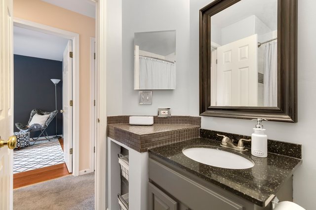 Undisclosed Address Bartlett, IL 60103 - Photo 28 of 45 a en suite bathroom with a granite countertop sink and a mirror