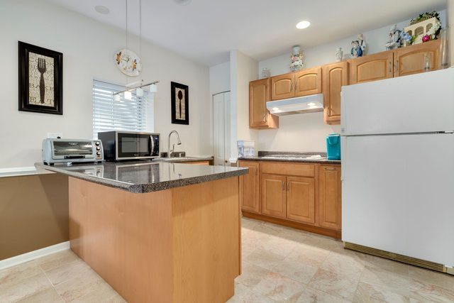 Undisclosed Address Bartlett, IL 60103 - Photo 34 of 45 a kitchen with granite countertop a refrigerator a sink a stove a microwave a counter top and white cabinets