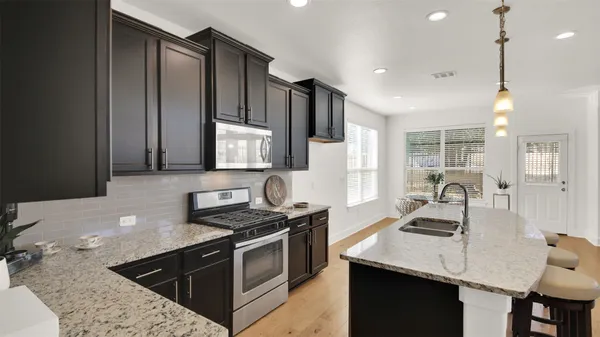 a kitchen with stainless steel appliances granite countertop a sink stove and refrigerator