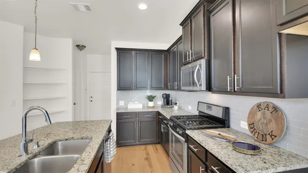a kitchen with a sink a stove and cabinets