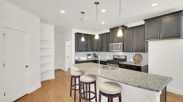 a kitchen with granite countertop a sink and a refrigerator
