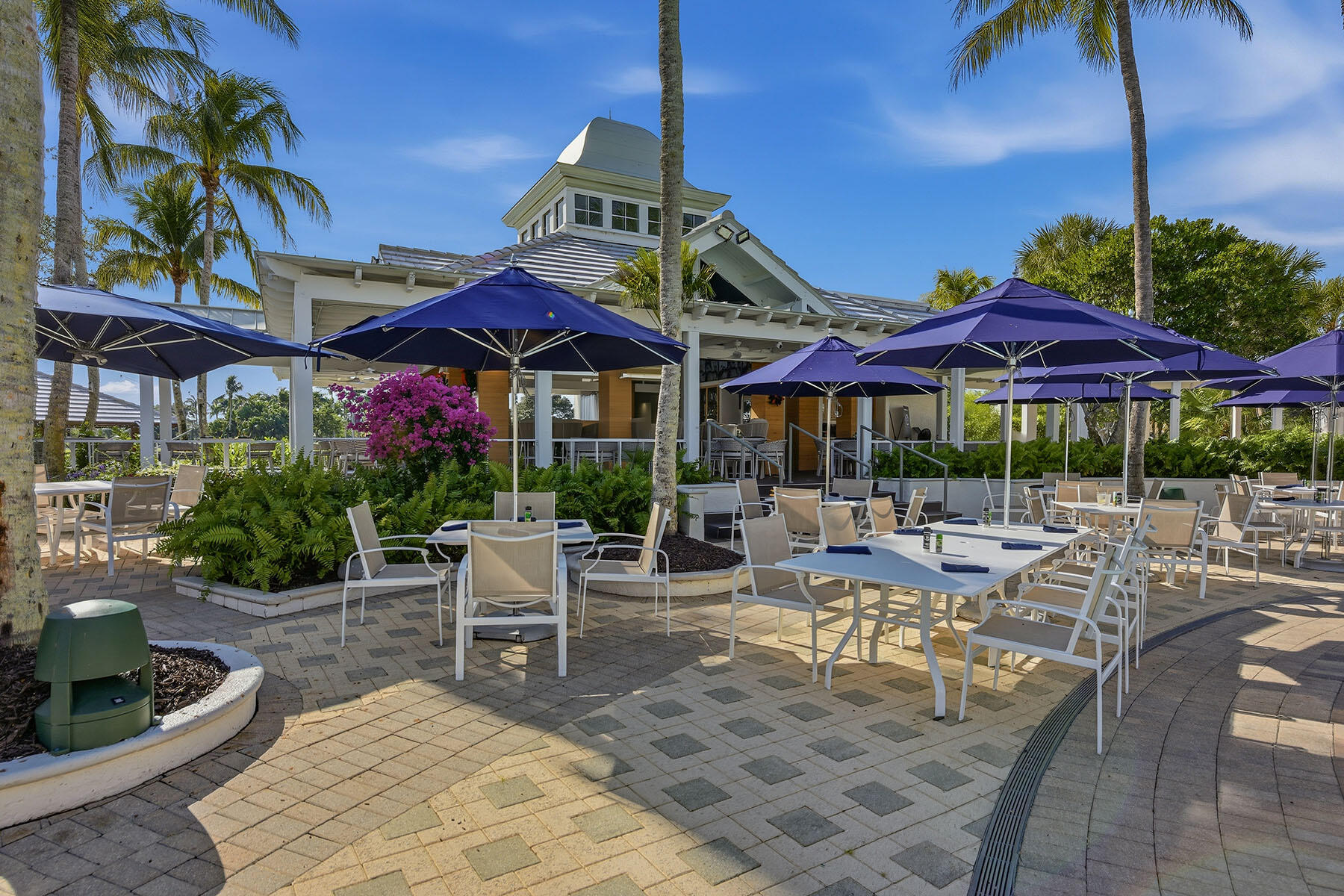 3291 Dorado Lane, Unit 101 Naples, FL 34114 - Photo 38 of 50 a view of a patio with chairs and table under an umbrella