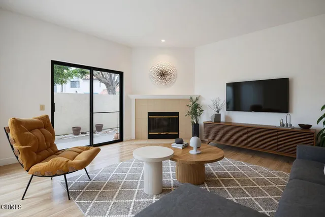 a living room with furniture a flat screen tv and a fireplace