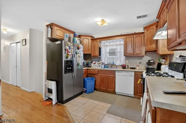 a kitchen with stainless steel appliances granite countertop a refrigerator and a stove top oven