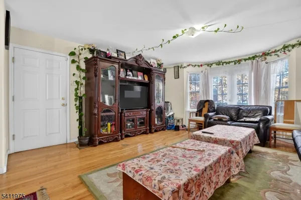 a living room with furniture a flat screen tv and a large window