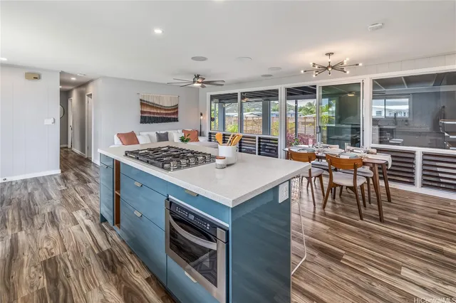 a open kitchen with stainless steel appliances granite countertop a stove and a wooden floors