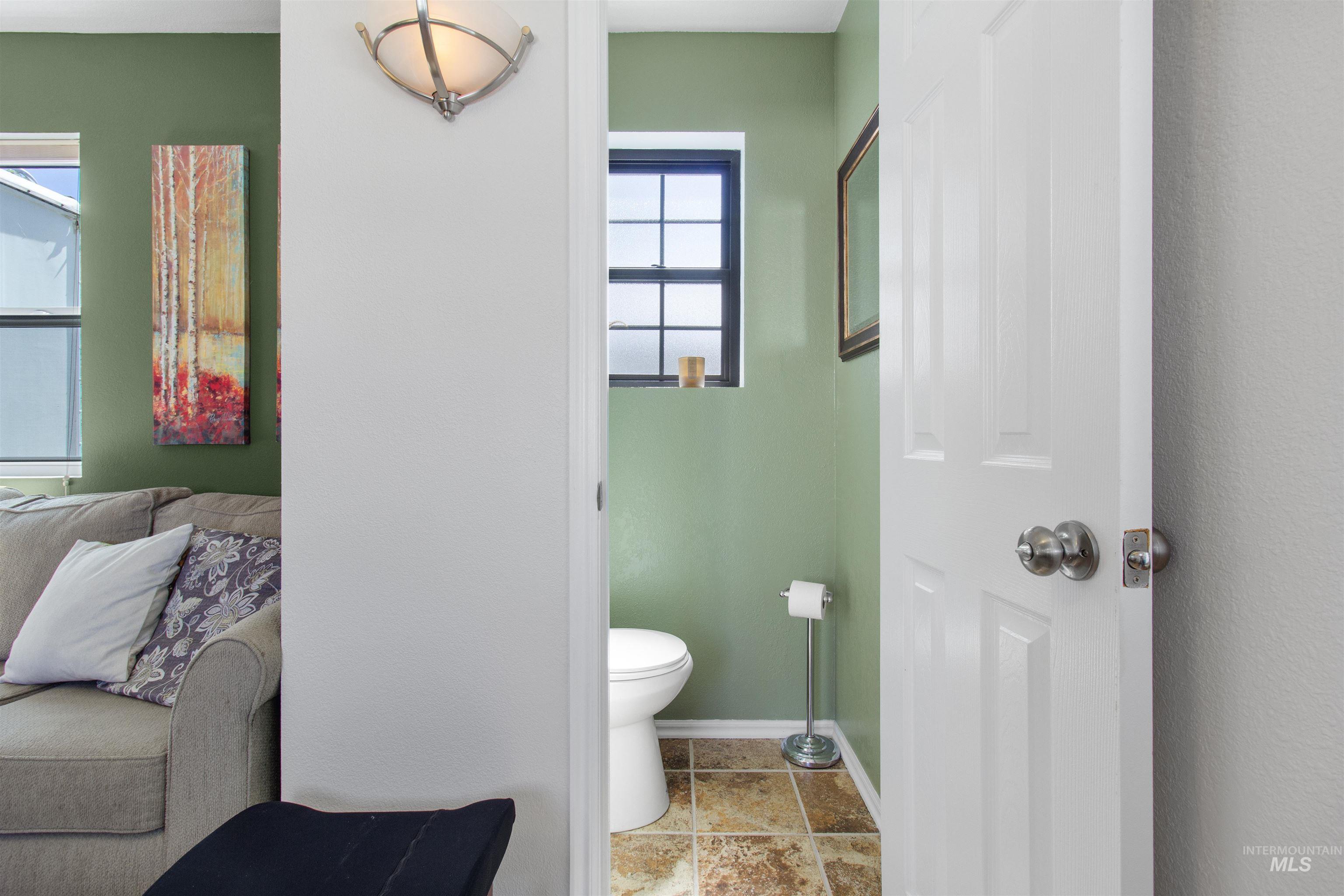 106 West Magic Road Shoshone, ID 83352 - Photo 11 of 45 Bathroom featuring a white toilet, small dark-framed window, and patterned floor tiles
