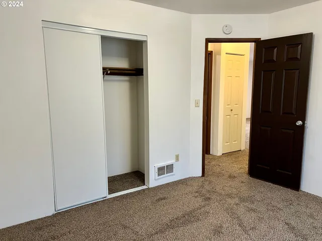 an empty room with closet and wooden door