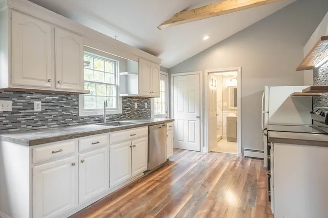 a kitchen with granite countertop white cabinets and white appliances