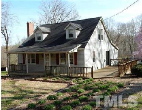 1027 Cavel Chub Lake Road Roxboro, NC 27574 - Photo 1 of 17 a front view of a house with garden