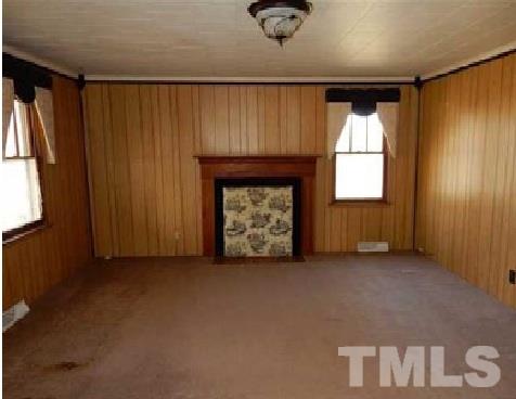 1027 Cavel Chub Lake Road Roxboro, NC 27574 - Photo 9 of 17 an empty room with windows and fireplace