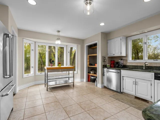 a view of kitchen with windows and refrigerator