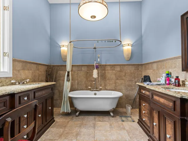 a bathroom with a double vanity sink mirror and bathtub