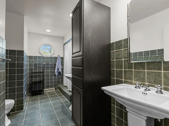 a bathroom with a sink toilet a mirror and shower