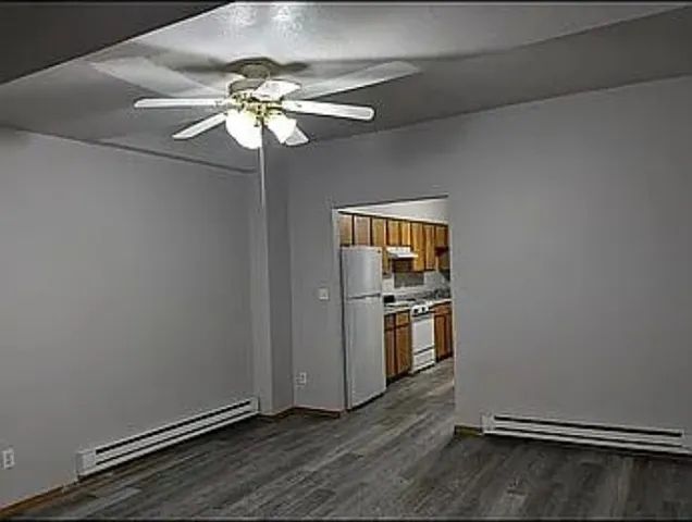 an empty room with wooden floor closet and chandelier fan