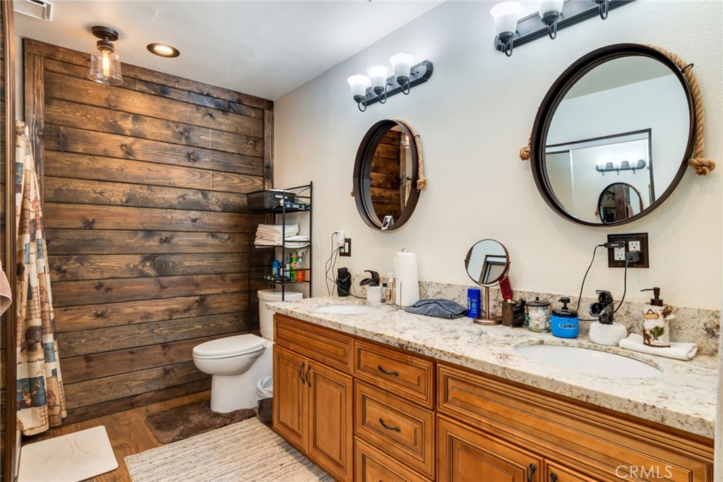 3198 Bexfield Court Riverside, CA 92503 - Photo 18 of 22 a bathroom with a granite countertop toilet a sink and a mirror