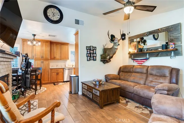 a living room with furniture a clock on the wall and a flat screen tv