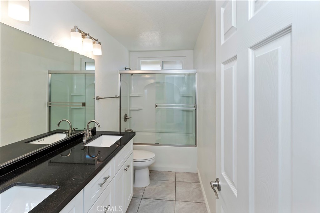 9152 Owari Lane Riverside, CA 92508 - Photo 11 of 20 a bathroom with a granite countertop sink a toilet and shower