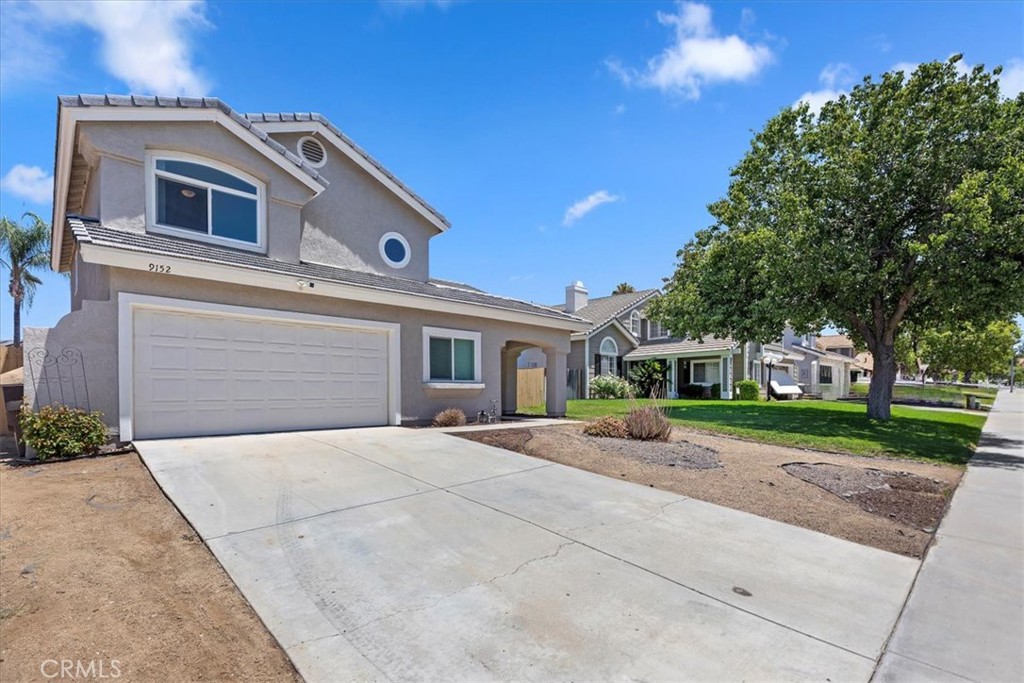 9152 Owari Lane Riverside, CA 92508 - Photo 2 of 20 a front view of a house with a yard and garage