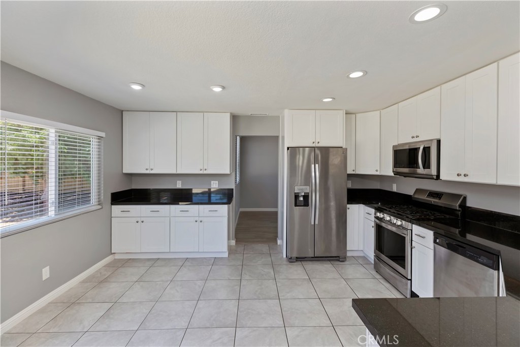 9152 Owari Lane Riverside, CA 92508 - Photo 6 of 20 a kitchen with a sink a counter top space stainless steel appliances and cabinets