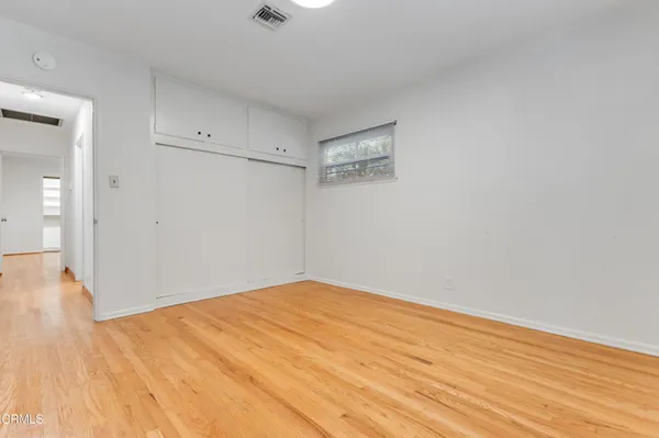 a view of empty room with wooden floor
