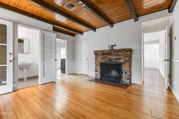 a view of a livingroom with wooden floor and a fireplace