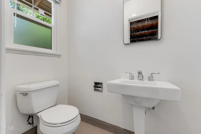 a bathroom with a toilet a sink and mirror