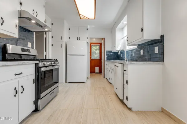 a kitchen with stainless steel appliances granite countertop a stove and a refrigerator
