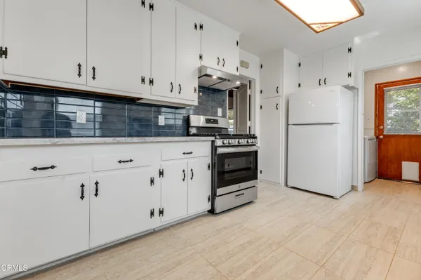 a kitchen with white cabinets and white appliances