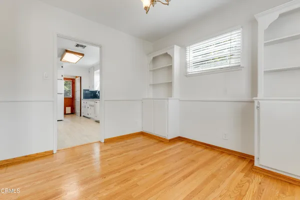a view of empty room with wooden floor