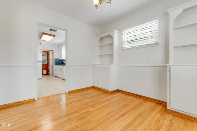 a view of empty room with wooden floor