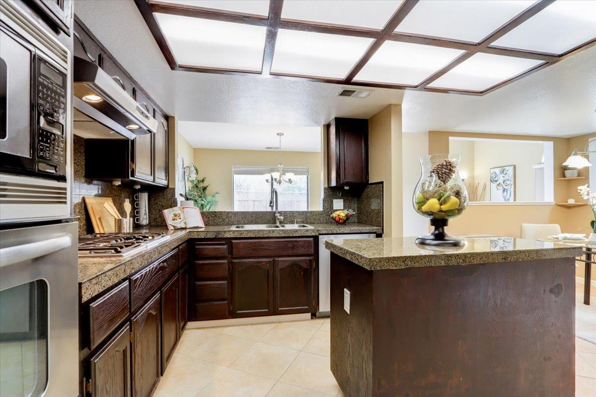 945 Oak Park Drive Morgan Hill, CA 95037 - Photo 17 of 46 a kitchen with stainless steel appliances granite countertop a sink and stove
