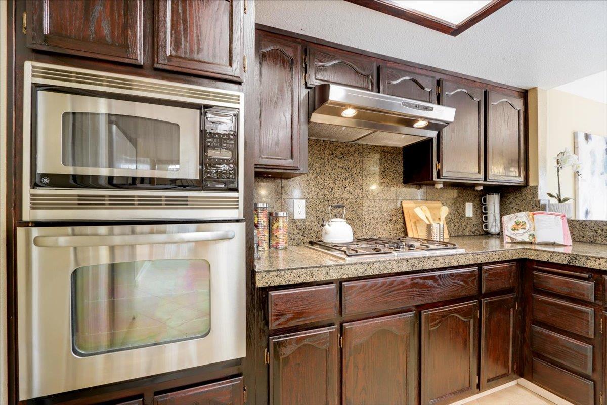 945 Oak Park Drive Morgan Hill, CA 95037 - Photo 18 of 46 a kitchen with stainless steel appliances granite countertop a stove microwave and cabinets