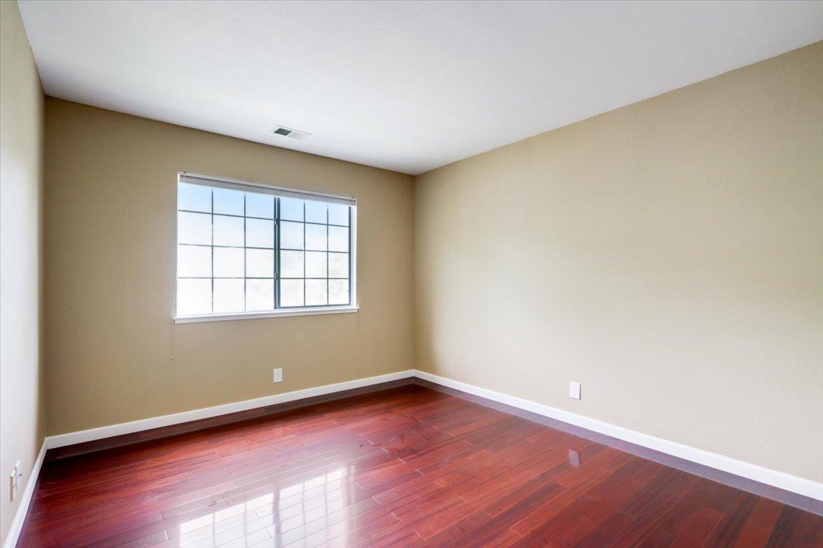 945 Oak Park Drive Morgan Hill, CA 95037 - Photo 32 of 46 an empty room with wooden floor and windows