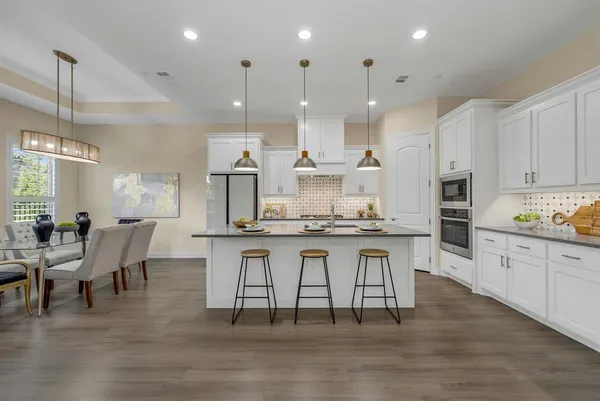 a large kitchen with kitchen island a sink table and chairs
