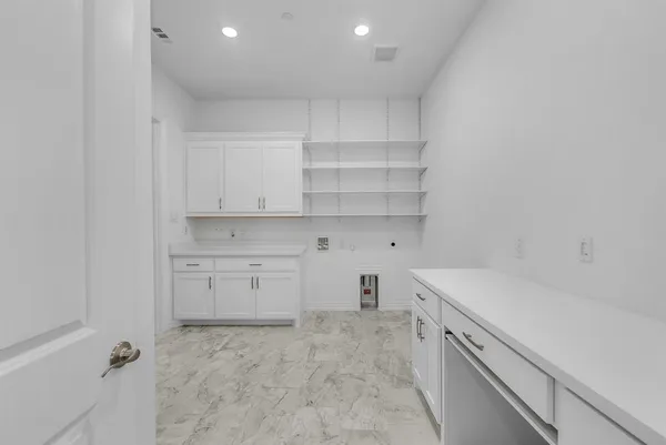 a view of a kitchen with white cabinets and sink