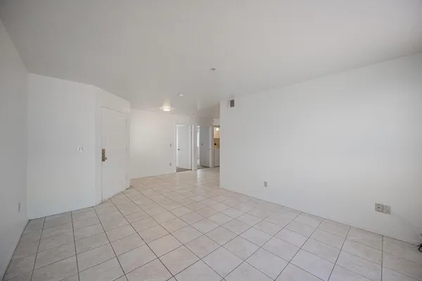 a view of a kitchen with white cabinets and refrigerator