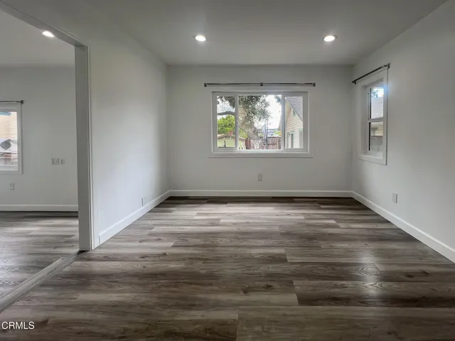 an empty room with wooden floor and window