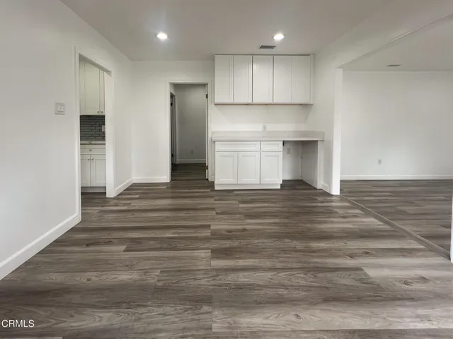 a view of a kitchen with wooden floor and electronic appliances