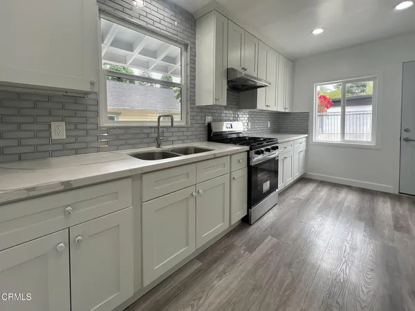 a kitchen with a sink a stove and cabinets