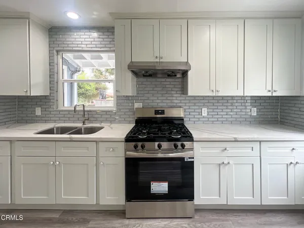 a kitchen with cabinets appliances and a sink