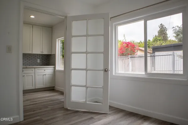 a kitchen with white cabinets and wooden floor