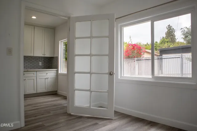 a kitchen with white cabinets and wooden floor