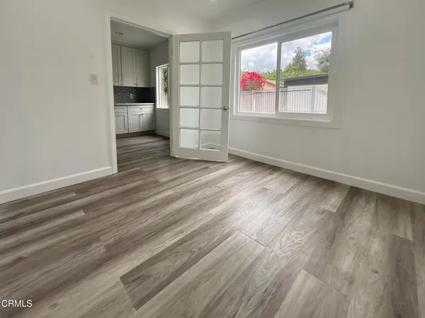 an empty room with windows and cabinet