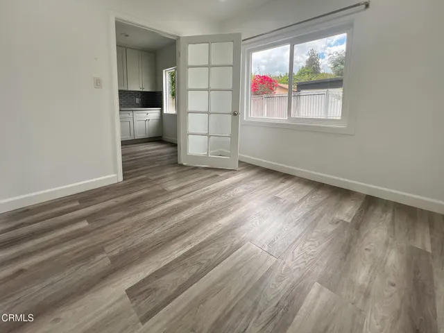an empty room with windows and cabinet