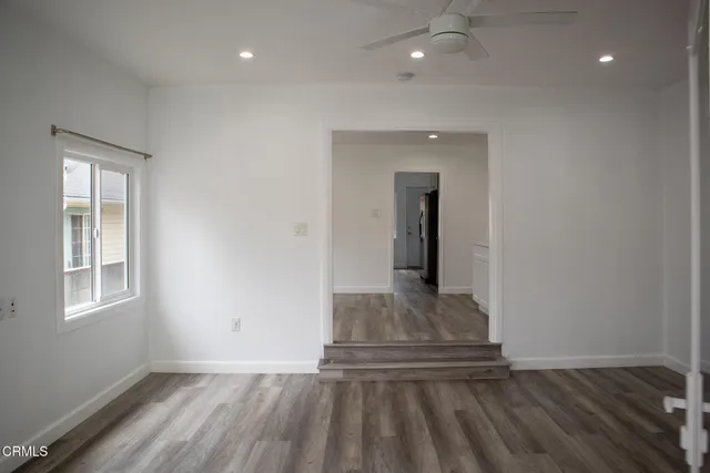 a view of hallway with window and wooden floor